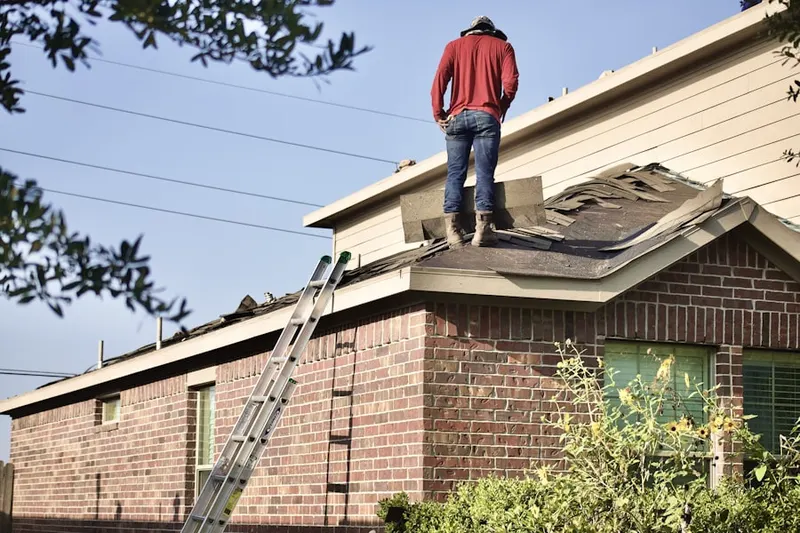 Professional roofer working on a residential roof in The Willows